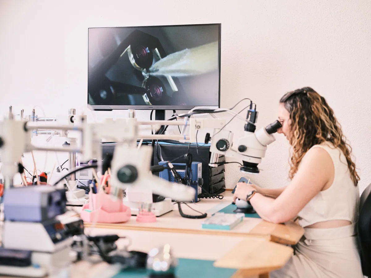 Alexandra Schmitz à la binoculaire avec caméra haute définition et écran 4K dans l’atelier Art de l’Anglage